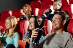 cinema, entertainment and people concept - happy friends watching movie in theater