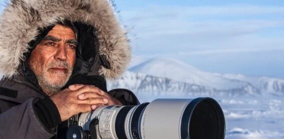 Photographer with a telephoto camera in a snowy Arctic landscape